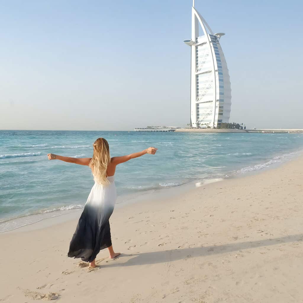 woman on the beach with building in Dubai in the background